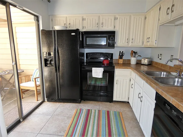 The kitchen is equipped with dishes, cookware, etc. There is an opening from the kitchen to the dining area.