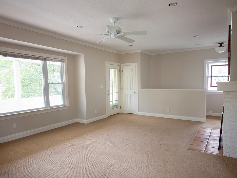 Spacious sun-filled living room with neutral decor.