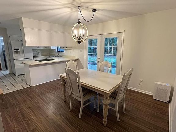 Dining area with a notable chandelier, hardwood / wood-style flooring, and french doors