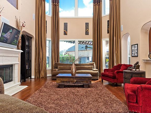 Floor to ceiling windows illuminate the Family Room with natural light while the fireplace serves as the focal point of this elegant yet cozy space.