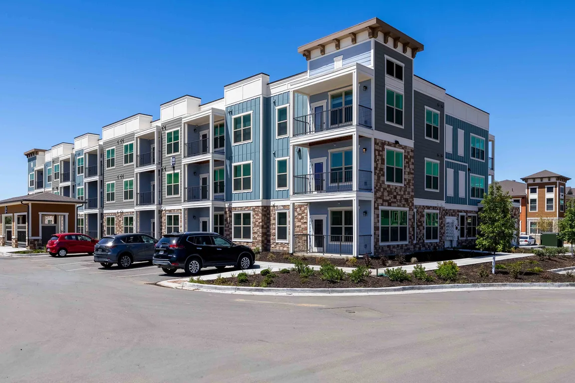 Garrett Parker's three story residential buildings combine stone, siding, and paneled accents across a landscaped community in Parker, CO.