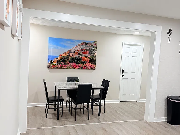 Dedicated dining area with a four-seat table, wide entry opening, and durable wood-look flooring for easy upkeep.
