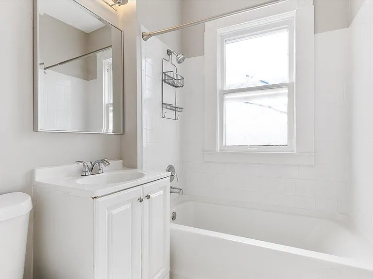 Light and bright bathroom has fresh paint, newer mirror and light.