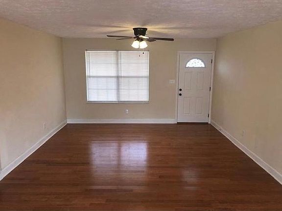Open concept living room that leads to fenced in backyard.
