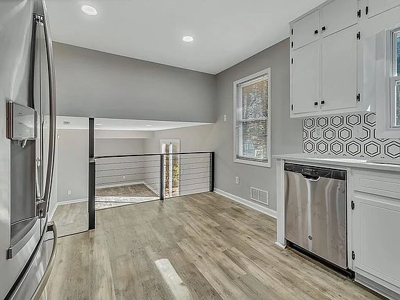 A small staircase in the kitchen leads down to the den with a half bath, access to the garage and a sliding backdoor.