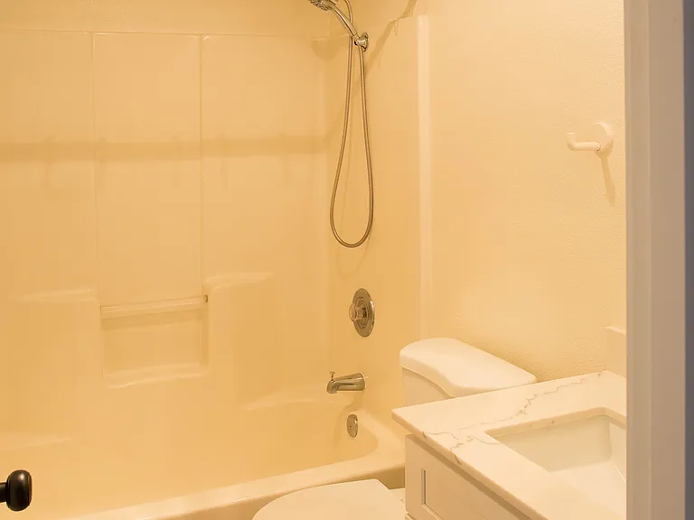 Second-floor full bathroom with brand-new finishes, conveniently shared between both bedrooms. Bright functional layout with bathtub and shower combination.