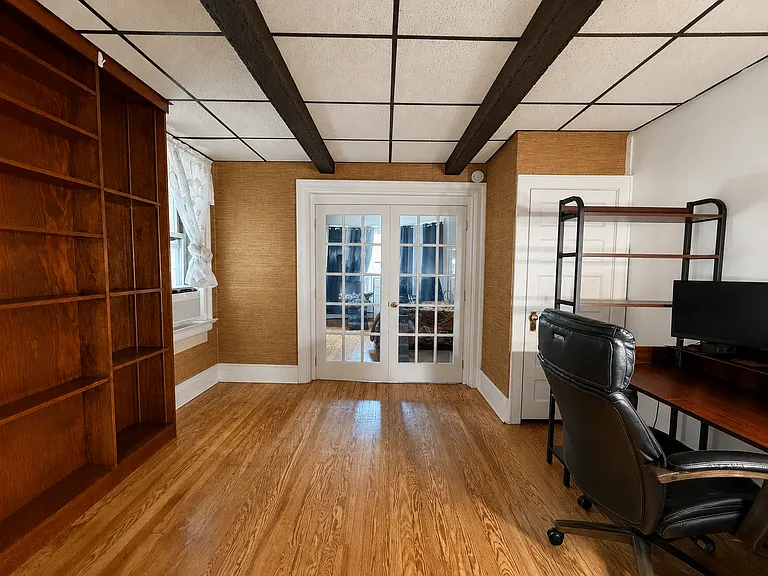 Huge living room with plenty of space for office area/ dining area - closet behind the white door. built in shelving to the left.