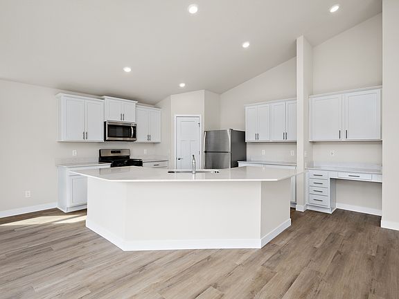 The kitchen has stainless steel appliances and plank flooring