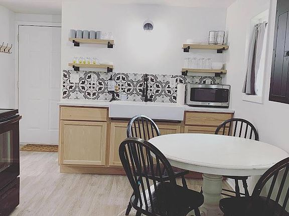 Kitchen with electric stove, refrigerator, microwave, and coffee maker