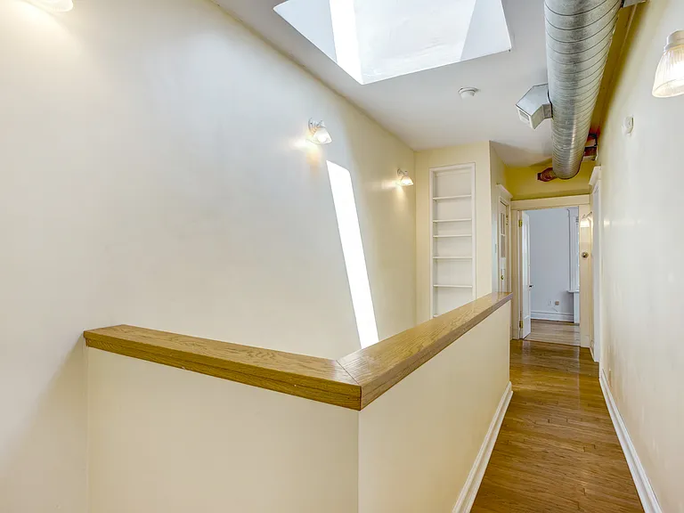 Second floor hall with skylight and bookcase at the top of the stairs