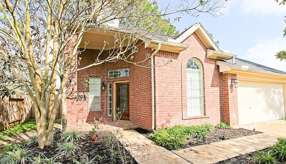 Large front yard with shady trees and two car garage.