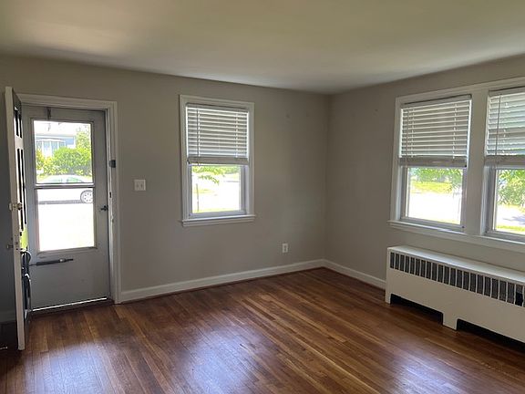 Living room with fresh paint, refinished wood floors, new blinds.