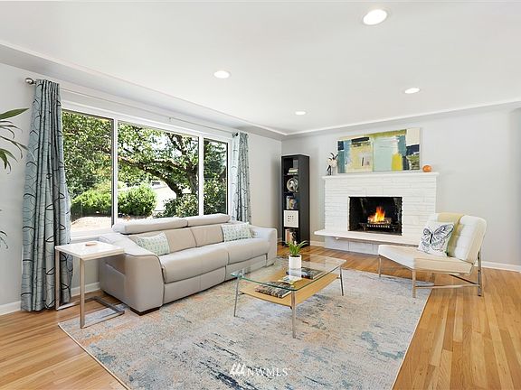 A cozy wood burning fireplace warms the open and airy living room.