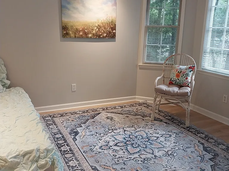 The fourth bedroom boasts ample natural light from a bay window
