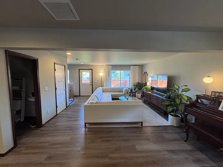 Photo taken from front door. Kitchen on left, dining room on right. Open door on left is for half bath. Closed door on left is the under stairs storage closet. (FURNISHINGS NOT INCLUDED. Photo shows vinyl flooring throughout main floor).