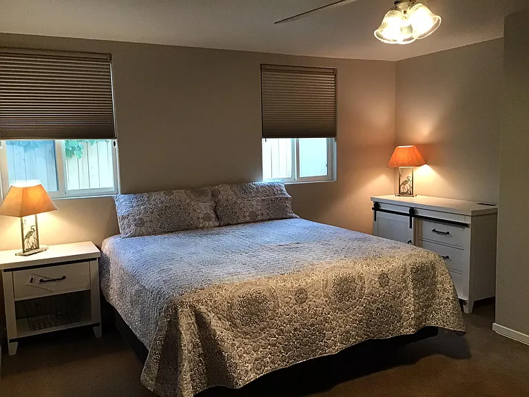 En suite primary king bedroom with full bath and large screen TV