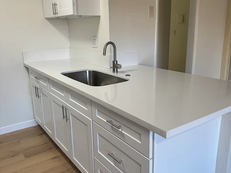 White quartz kitchen countertops and well-designed eat-in counter perfect for both entertaining and everyday living.