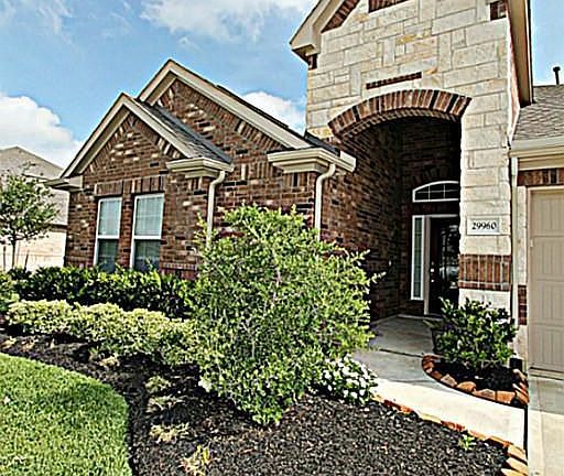 LUSH LANDSCAPING AND A MANICURED LAWN WELCOMES YOU HOME