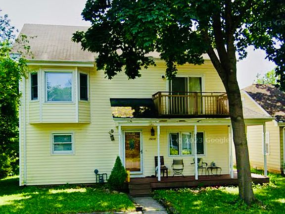 Front of house showing the bay windows on left in a bedroom on 2nd floor and wrap around deck on 1st floor exterior and private balcony off bedroom on 2nd floor.
