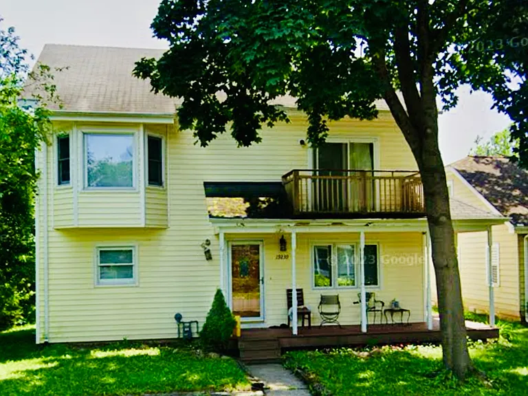 Front of house showing the bay windows on left in a bedroom on 2nd floor and wrap around deck on 1st floor exterior and private balcony off bedroom on 2nd floor.