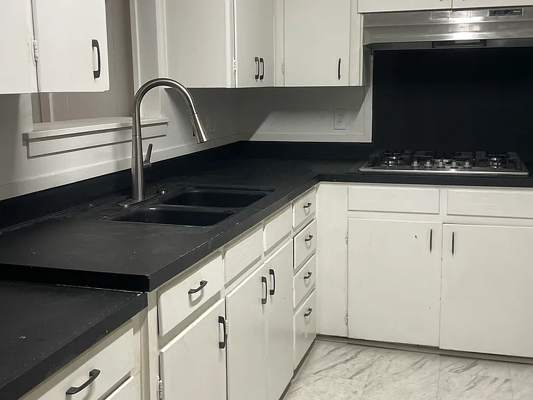 Kitchen sink, cabinets, and gas stovetop
