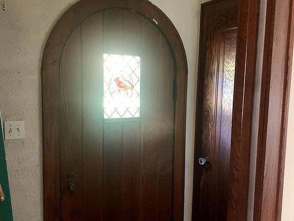 Front foyer with glass panel wood door leading to living room. Entrance alcove has storage closet and downstairs 1/2 bath.