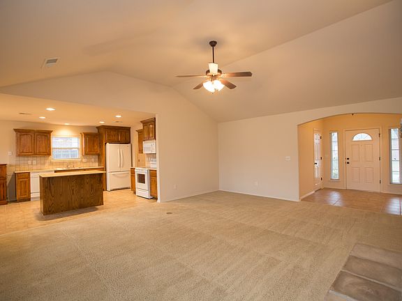 Great open living space with view of kitchen and entry.