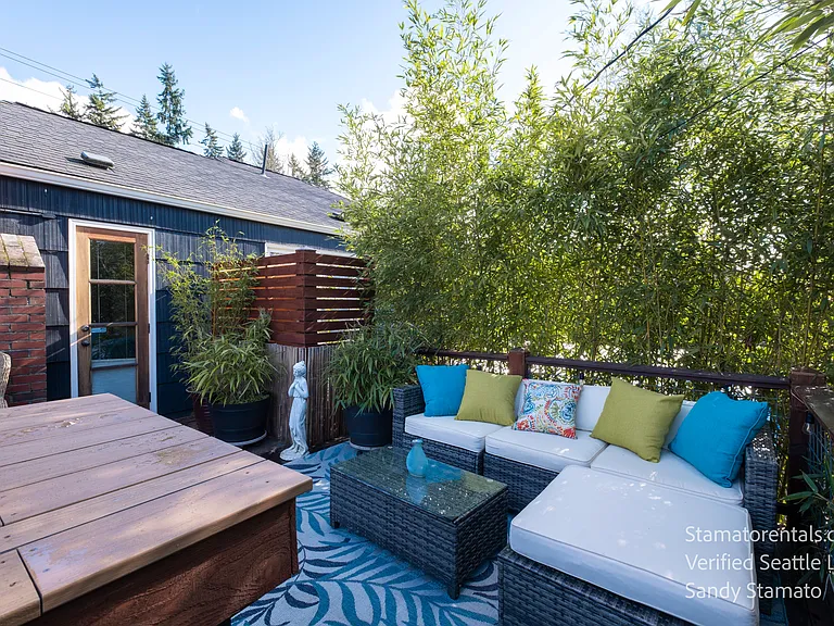 French doors open to a private upper deck surrounded by bamboo and open skies.