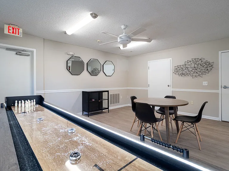Enjoy friendly competition in our recreation room featuring shuffleboard and seating for spectators, professionally operated by Highlands Vista Group.