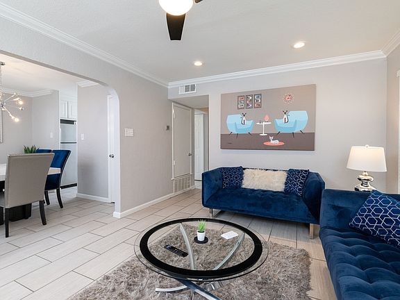 Spacious living room with couch, fireplace and flat screen TV with natural light.