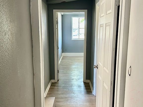 Hallway off of kitchen that goes to isolated primary bedroom, laundry room and 2nd bedroom.
