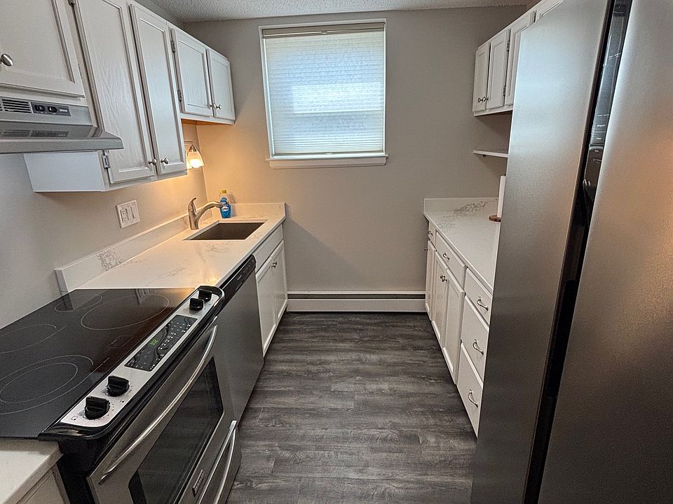 Kitchen with new stainless steel appliances; oven/cooktop, dishwasher, garbage disposal, large refrigerator/freezer. Multiple cabinets and drawers upper and lower, quartz countertops, vinyl floor