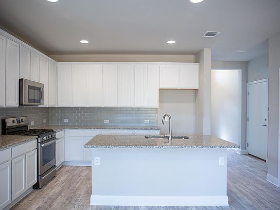 Granite countertops and fresh white cabinets with large island