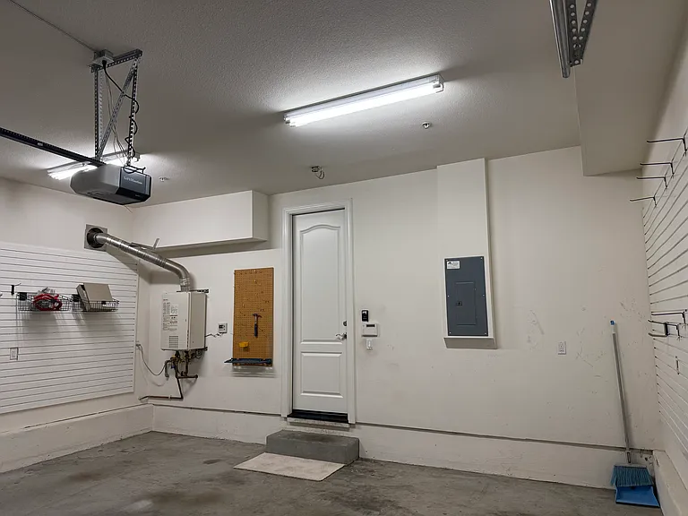Attached 2-car garage features organized shelving.