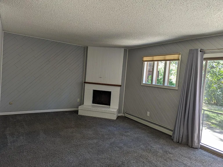 Large living room features a wood burning fireplace and sliding glass doors to the river-front patio. Lawn maintained by HOA - no fences.