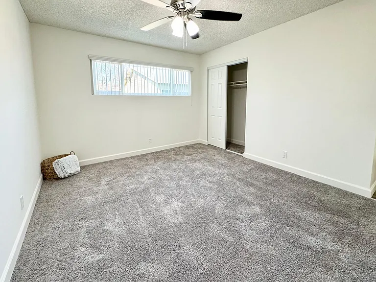 Spacious bedroom with dual pane windows and ceiling fan