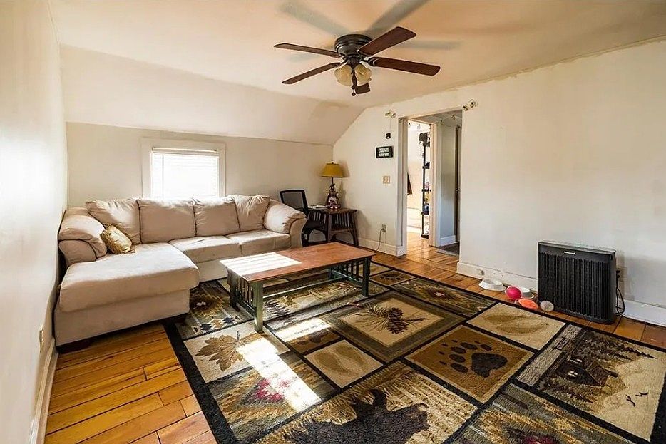 Living room with ceiling fan and orginal hardwood floors throughout.