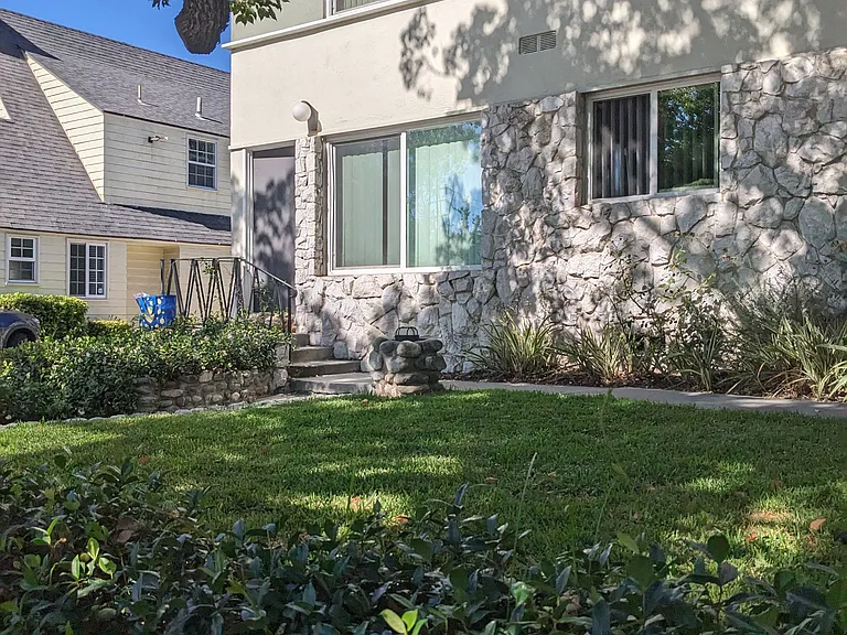 Lush gardens and shaded grass area inside gates of Los Robles Apartments in Pasadena, California.