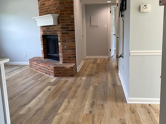 View at the top of the steps looking down the hallway with the family room to the left and the dining room/kitchen to the right.