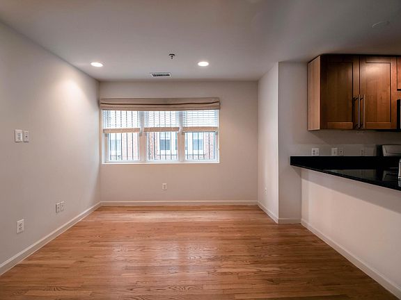 Den with 3 large windows and open kitchen.