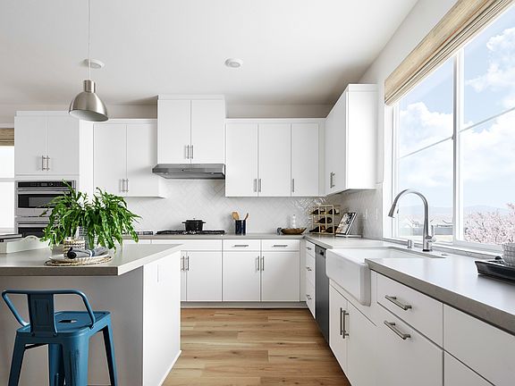 A modern, bright, and spacious kitchen with white cabinets, stainless steel appliances, and a large