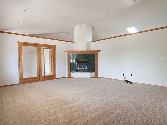 Large living room with gas fireplace and grooved glass doors.
