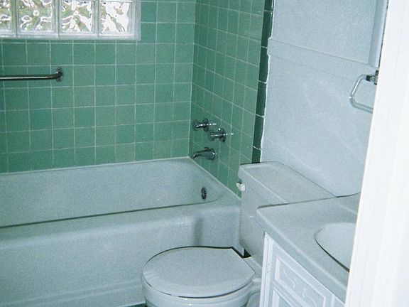 Bathroom has ceramic tile and a glass block window