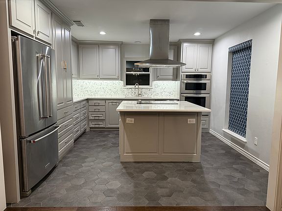 Fully updated kitchen including stainless steal fridge, oven and microwave, dishwasher, and range hood.