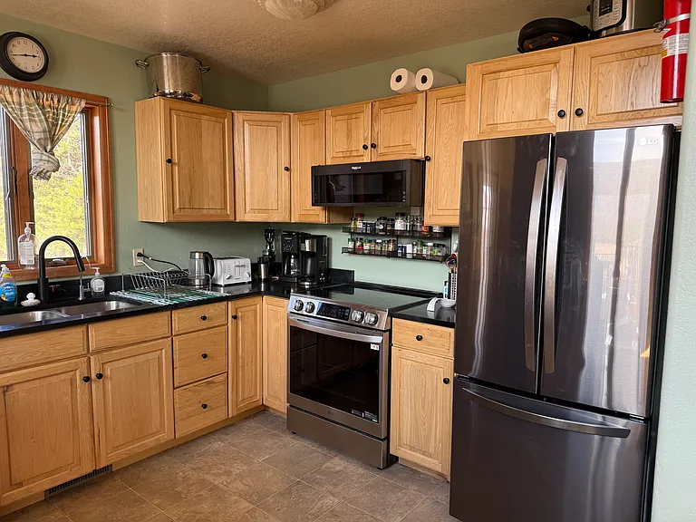 Kitchen with updated appliances and soapstone counter.