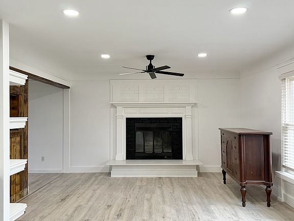 Living room with fireplace, ceiling fan and new flooring