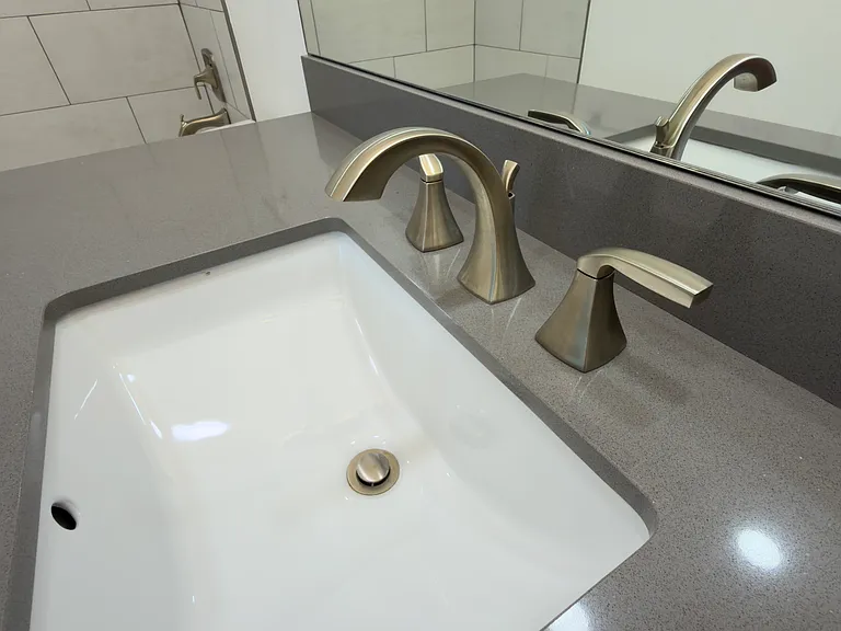 Sleek undermount sink set in elegant quartz countertops.