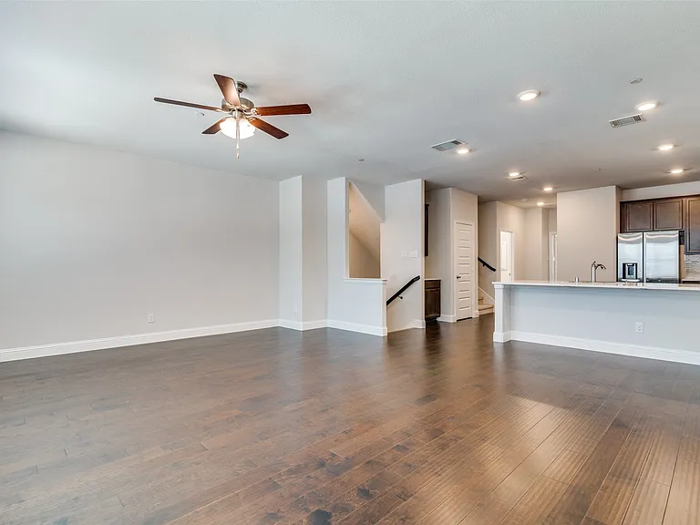Spacious living area featuring wood-finish flooring, recessed lighting, and a ceiling fan