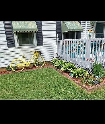 Flowerbeds wrap around porch