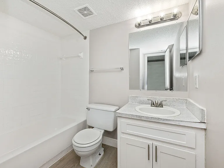 Chic modern bathroom with sleek white fixtures, elegant vanity, and contemporary lighting.